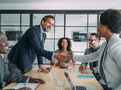 People shaking hands in a business meeting in a conference room