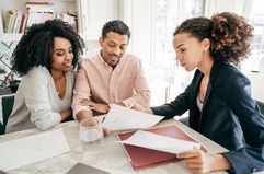 Couple talks to a businesswoman about getting tuition insurance for their child