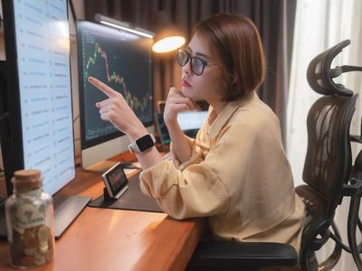 An investor studies a screen of stock data on a large monitor as they think about shorting a stock they hold.