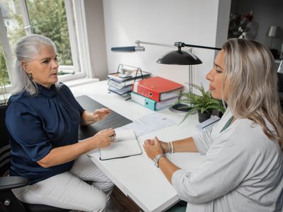 Two women sitting at a desk in an office