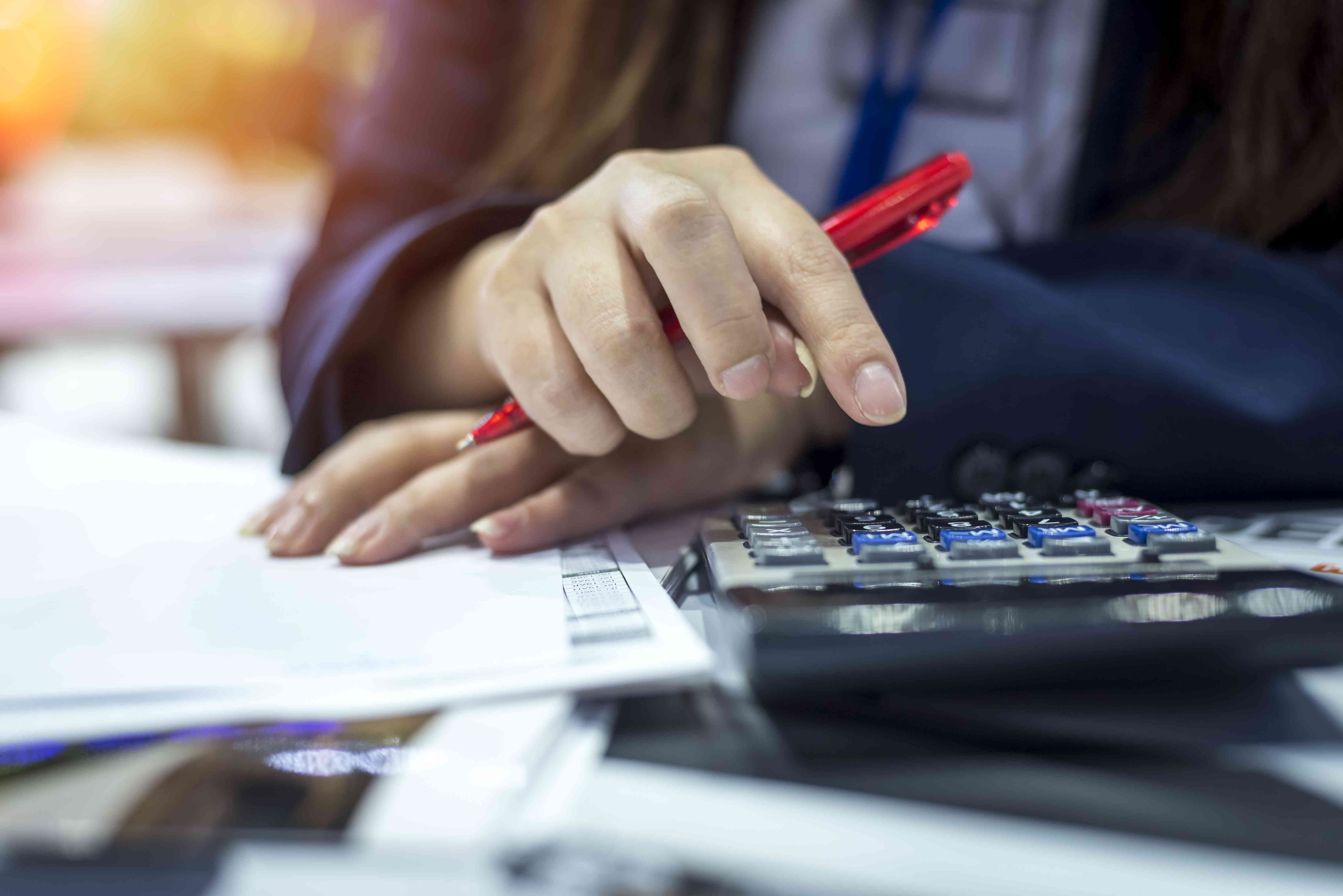 A person uses a calculator while looking over documents