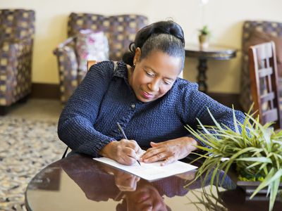 A woman fills out an application at a table.