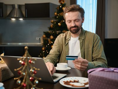 Man using his credit card to pay loan on his laptop