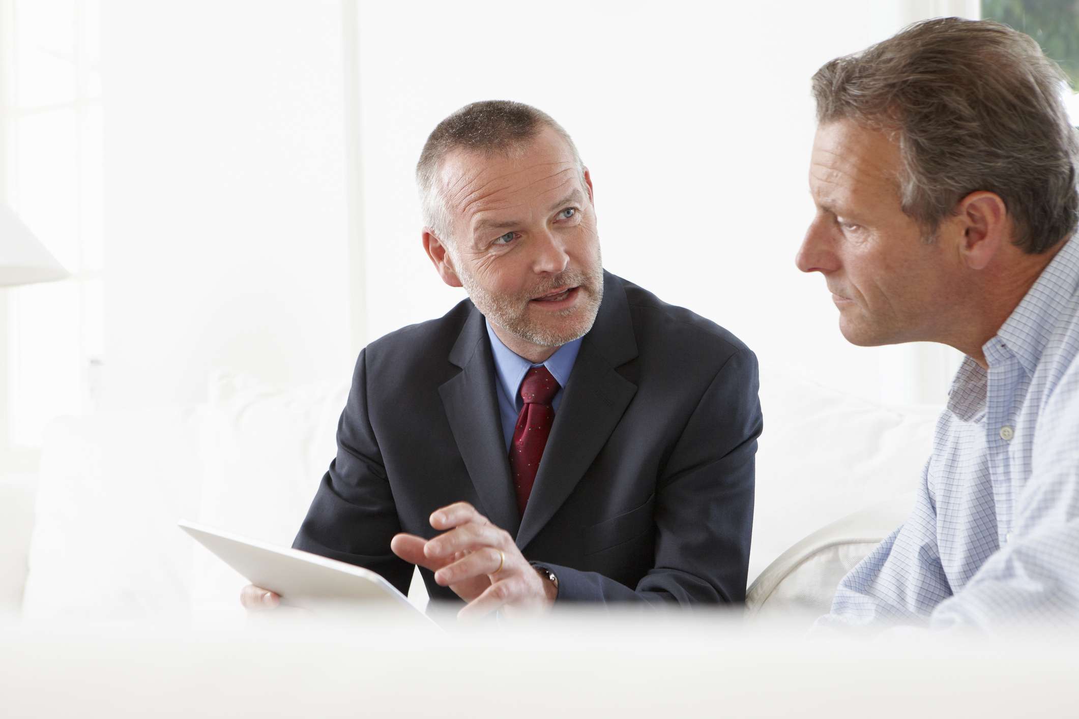 Financial advisor talking to customer in front of tablet.