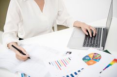 Businesswoman Analyzing Investment Charts With Laptop