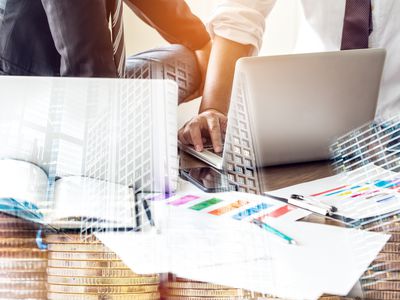 Financial Managers talking in front of laptops on a wooden table. on