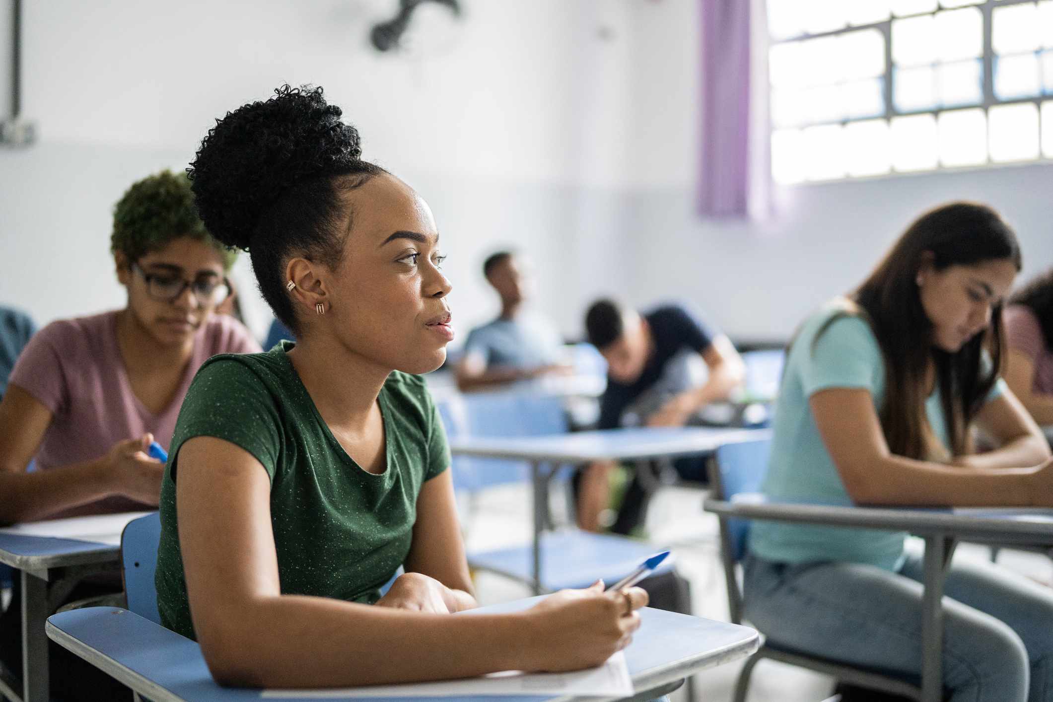 A student sits at a desk in a classroom.