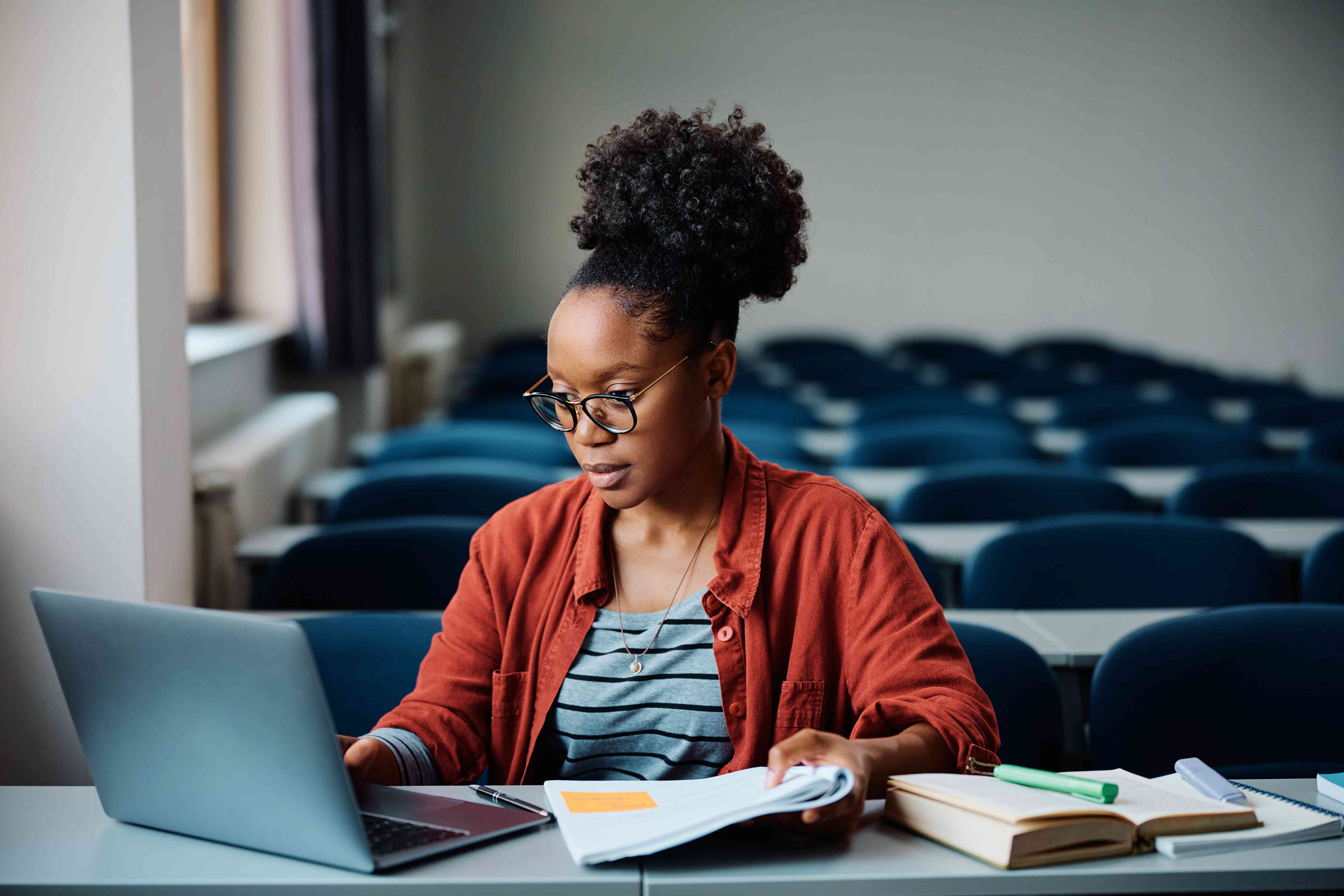 A female student calculates how much to pay on student loans with the standard repayment plan in a classroom.