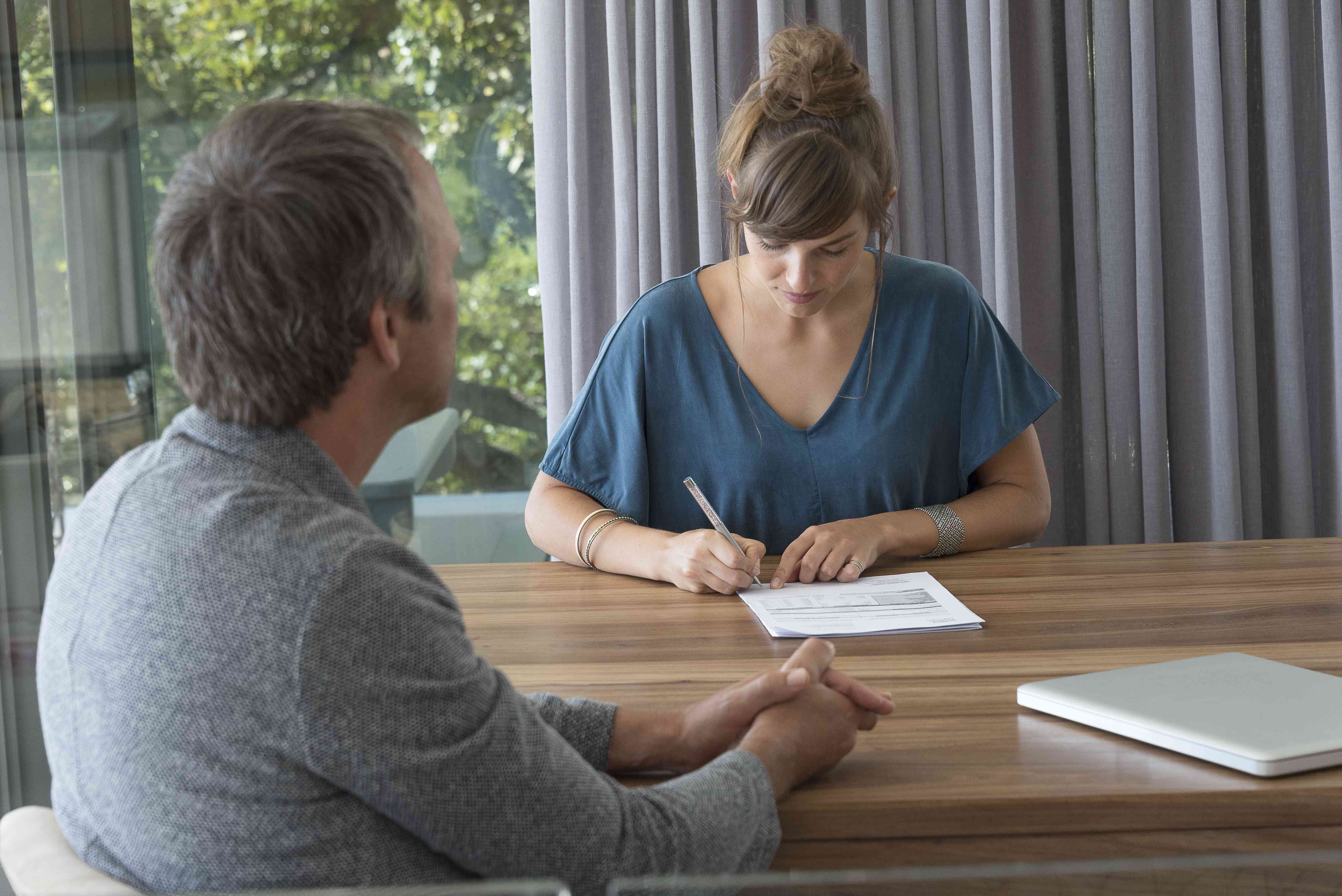 Woman signing papers for a divorce loan