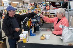 A man pays a cashier at Winter Harbor Provisions.