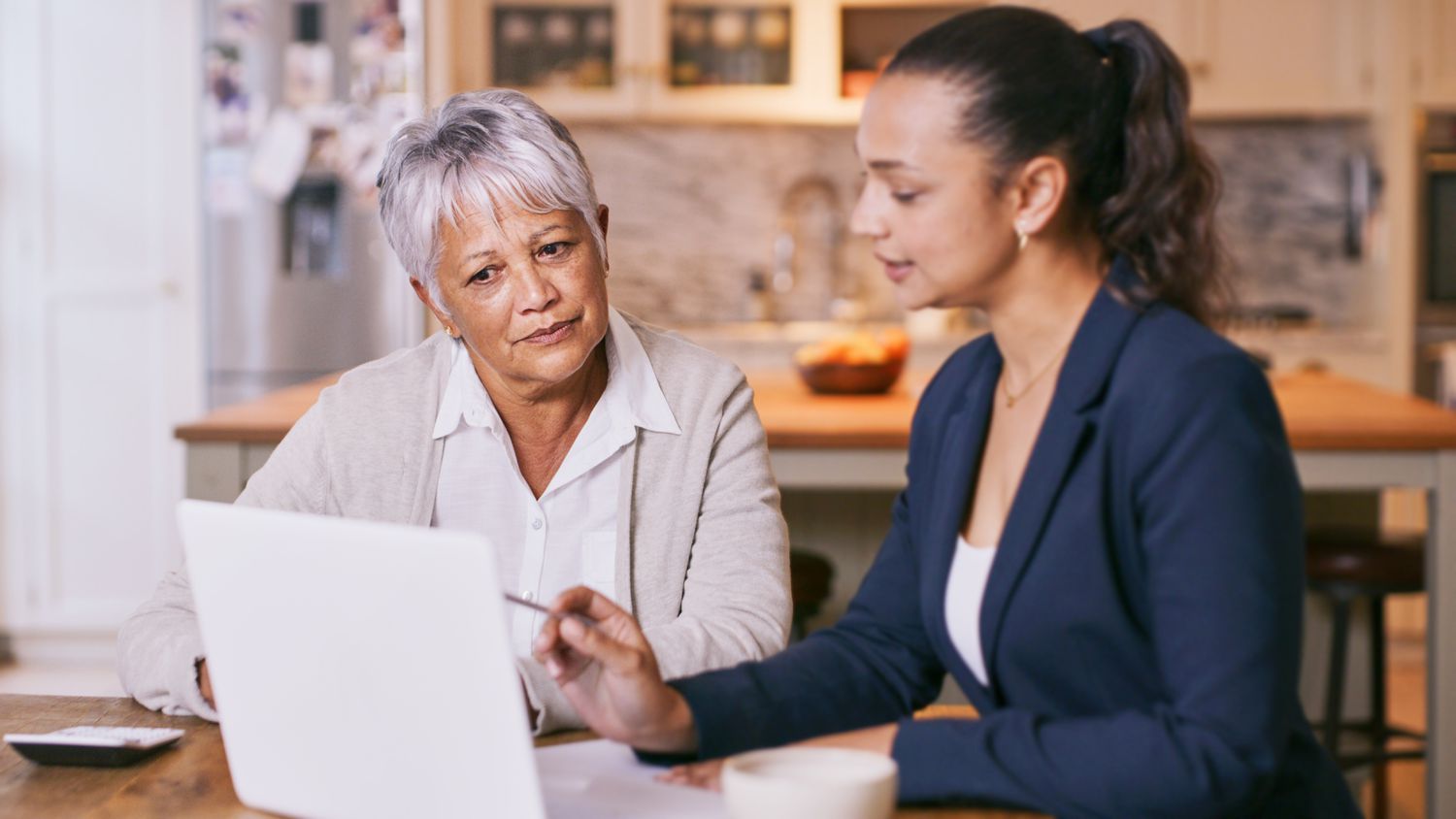 An older adult works with a lawyer as they discuss their last will and testament.