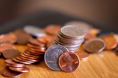 Stacks of coins with quarter and penny in front