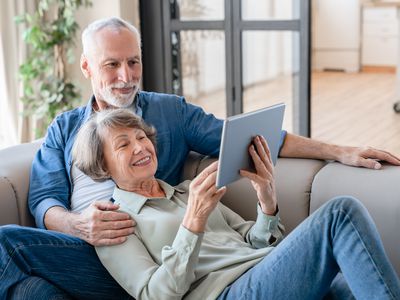 Couple sitting on a couch with a tablet