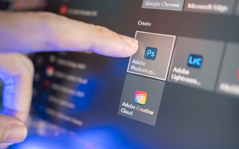 User using touch screen device choosing Adobe applications