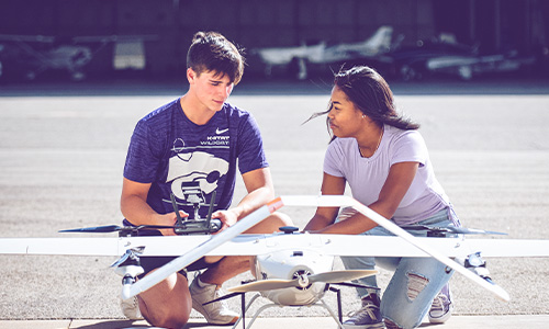 Two students working with at drone at K-State's Salina, Kansas campus