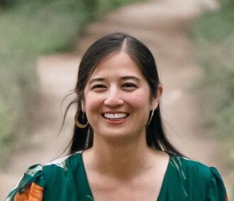 Lindsay Nakaki, a person with long dark hair wearing a green blouse, photographed outdoors.