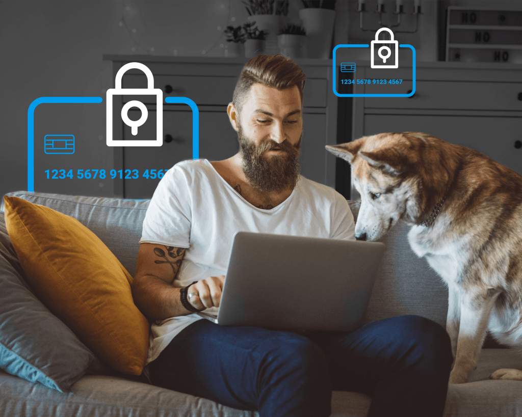 Rapaz sentado em um sofá olhando para um computador enquanto seu cachorro assiste ao lado dele. Ícones de cartões de crédito seguros estão ao fundo atrás dele.