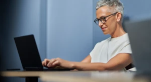 a man sitting at a table using a laptop computer