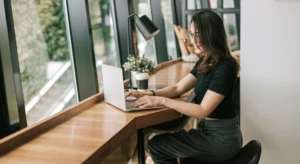 a woman sitting at a table using a laptop