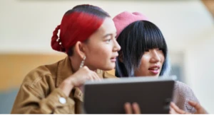 a man and a woman looking at a laptop