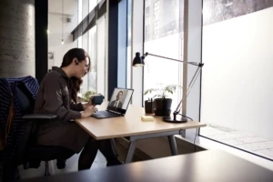 Female small business professional at desk using an Acer Spin 1 device running Microsoft Teams video conference call.