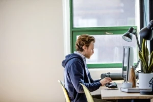 Young, small business male with All-in-one in modern workplace.