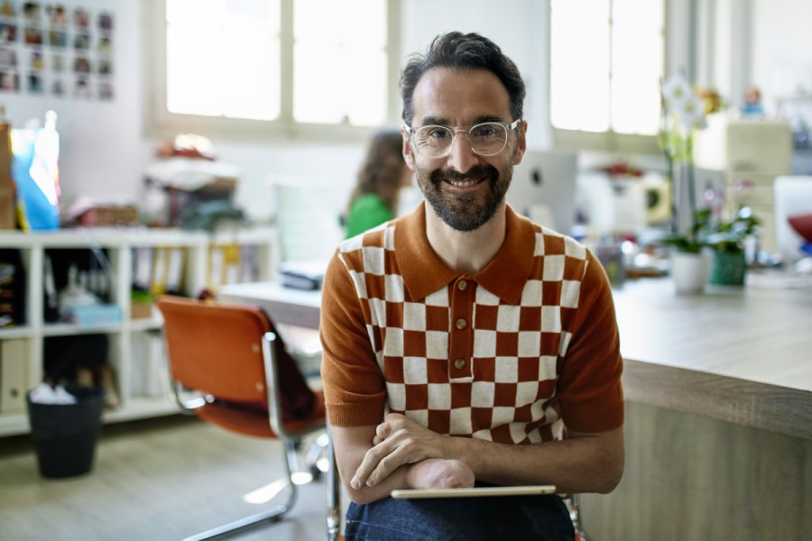 A marketing professional smiling for a portrait holding a tablet.