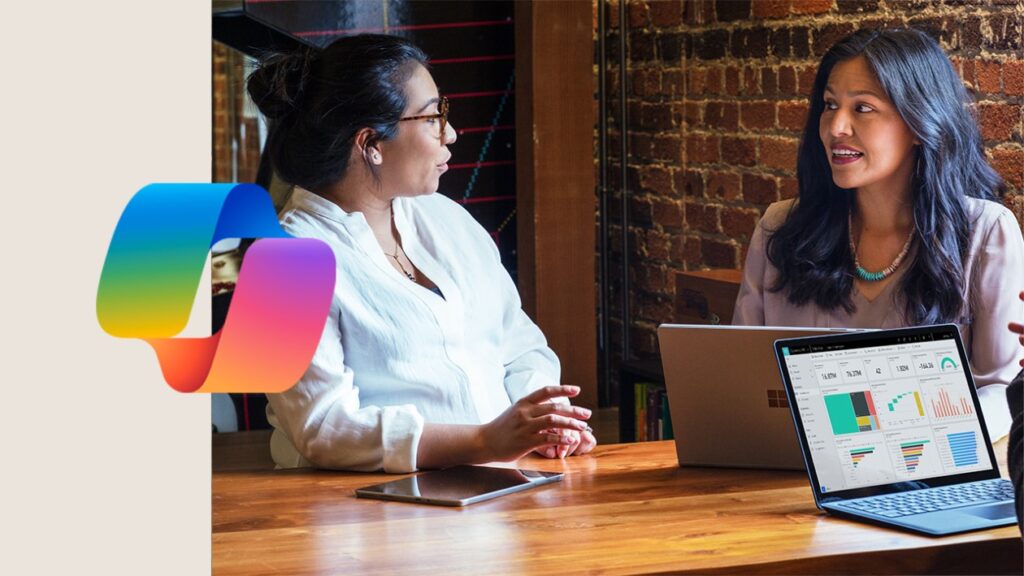 Image incorporating the Copilot icon and a photograph of people sitting at a table with a laptop.