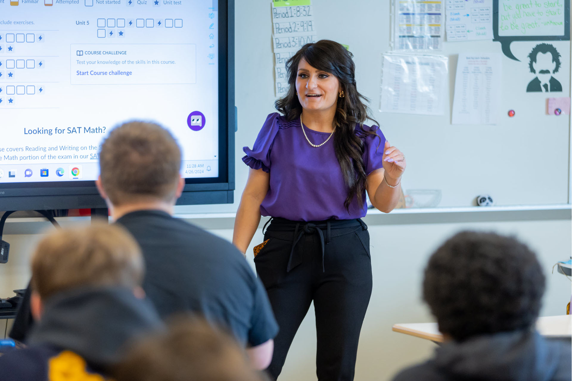 A teacher standing in front of a group of students, giving a lecture.