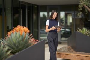 A woman participating in a Microsoft Teams meeting on her Surface tablet while on the go.