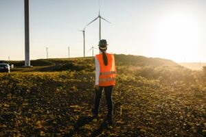 Female worker walking towards car in wind power field.