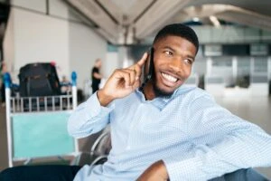 A person with a phone up to their ear smiling.