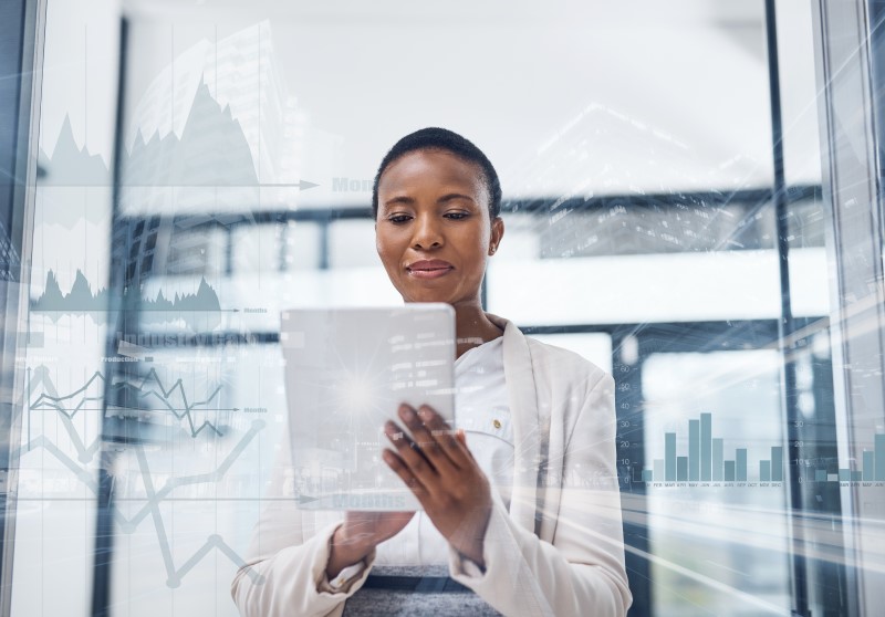 Multiple exposure shot of a mature businesswoman using a digital tablet in a boardroom superimposed on a cityscape.