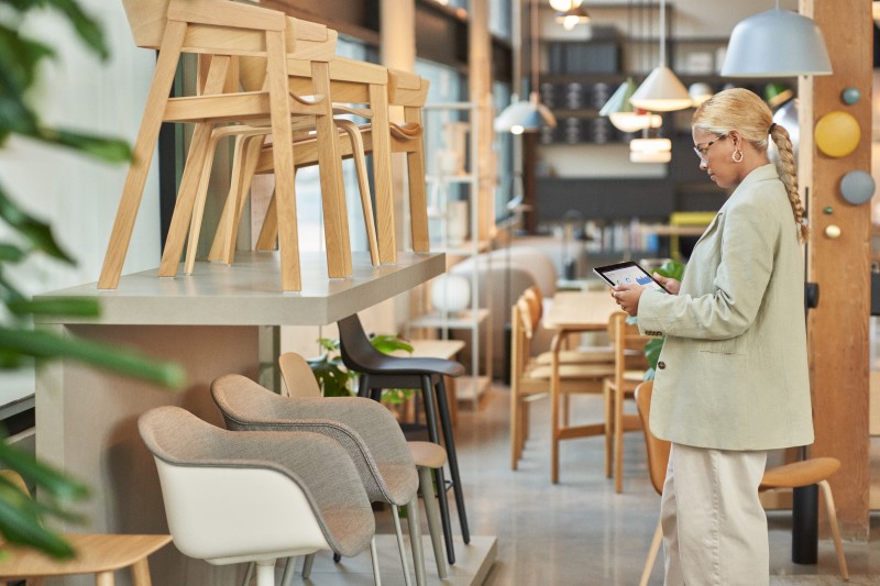 Retail store manager using a tablet to analyze floor and endcap data.