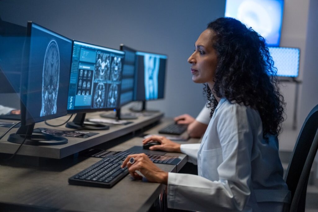 woman working on computer. Female doctor analyzing medical scan result