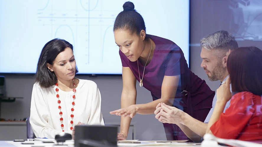 Financial Services Risk Image - group of business people  looking at documents on a table.