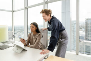 Two woman in an office looking at a Surface Pro 9 in Platinum in tablet mode.