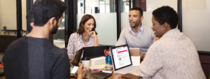 Image of four coworkers collaborating around a conference table.