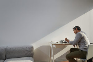 Adult male in home office environment sitting at a desk with a black Microsoft Surface Pro 7 in studio mode. Black Microsoft Surface Pen in hand.