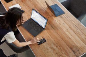 A woman reacting to a Teams meeting from her mobile phone while participating in a Microsoft Teams meeting.