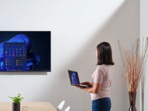 Business person working in hybrid office, displaying Windows 11 start screen.