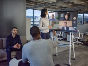 Hybrid team collaborating in modern office space and on Microsoft Teams.