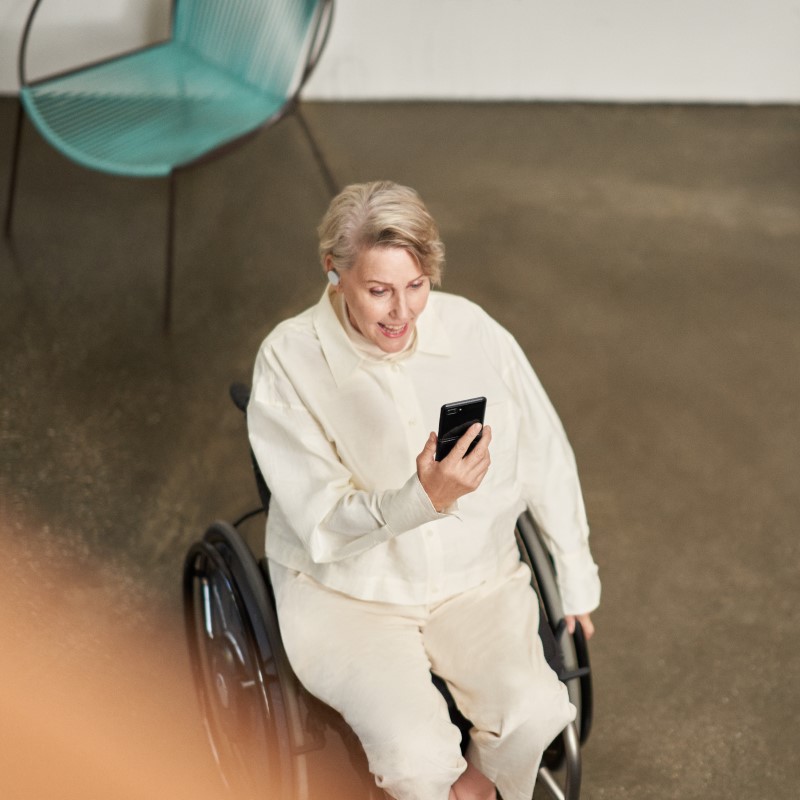 A woman participating in a Microsoft Teams meeting on her mobile device while on the go​.