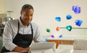 A small business owner sitting at a table using Microsoft 365 on a laptop computer