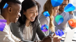 One woman and one man sitting and smiling at a computer, with Microsoft Teams and Copilot logos.