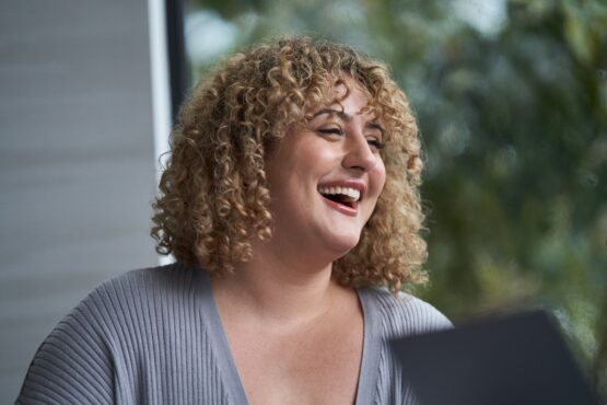 Close-up of woman looking to the side, smiling.