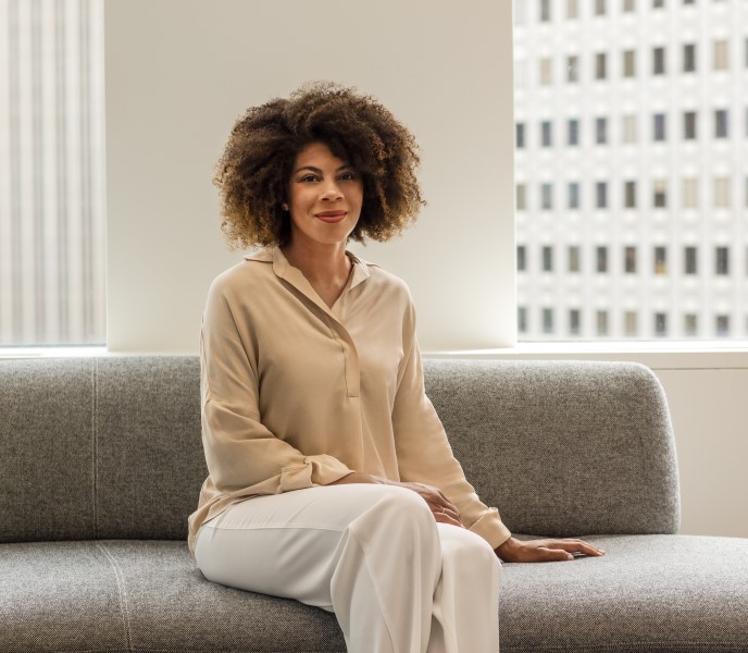 A portrait of a business leader sitting on a couch smiling