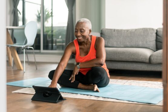 A woman taking a break from work and practicing yoga in her living room.