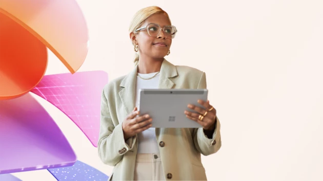 A tech worker holding a tablet and smiling