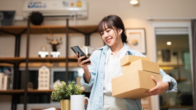 A woman standing in a retail store and using her phone.